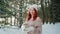 Pretty girl with red hair holding a burning candle in hands, flame candles, warming fire in winter forest,