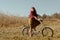 Pretty girl riding bicycle in field