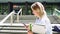 Pretty girl student holding cell phone using smartphone walking outdoors.