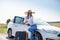 Pretty girl with suitcase standing near car and wiat for her dreaming trip