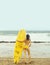 Pretty girl surfer in swimsuit holding yellow surfboard