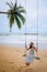 Pretty girl on swing with backgound of Nang Thong Beach in Khao lak lighthouse