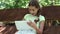 Pretty girl with tablet computer sits on the swing bench