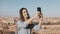 Pretty girl takes selfie in Jerusalem old town. Cute local girl smiles happy, taking photos. Ancient Israel panorama 4K.