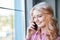 Pretty girl talking on the phone near a window. Business concept