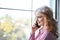 Pretty girl talking on the phone near a window. Business concept