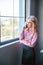 Pretty girl talking on the phone near a window. Business concept