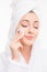 Pretty girl with towel on her head wash off makeup wiht closed eyes, close up photo