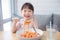 Pretty girl using fork eating spaghetti by herself