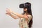 Pretty girl in VR glasses standing with outstretched arms and positive calm facial expression