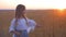 Pretty girl walk across the wheat field. Happy young girl running in the field at sunset. Freedom concept.