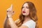 Pretty girl with wavy redhead holding symbolic gun with hand gesture