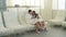 Pretty girl in white bathrobe is relaxing in day spa when her boyfriend is coming and sitting beside her. Young lovers