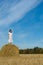 Pretty girl in white dress on haystack in field