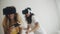 Pretty girls in VR helmets at home. Two women in modern virtual reality headsets playing video games and having fun