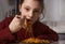Pretty grimacing kid girl eating tasty spaghetti on the dinner on the home kitchen. Closeup