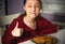 Pretty grimacing kid girl eating tasty spaghetti on the dinner on the home kitchen and showing thumb up sigh. Closeup
