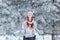 Pretty happy cheerful beautiful young girl with hair rydimi fun in the snowy woods and enjoys first snow in hat with scarf