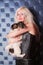 Pretty happy owner woman hugs her pappilon black and white puppy on dark background