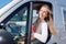 Pretty happy smiling blonde woman driving van or modern campervan in vanlife lifestyle concept