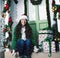 Pretty happy smiling young teenage hipster girl infront of decorated for Christmas house, waiting for guests coming