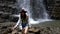 pretty hiker woman standing in front of big waterfall