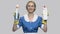 Pretty house maid holding two detergent bottles.