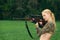 Pretty hunter girl aiming with hunting rifle in the outer wood. Carbine on the shoulder