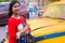 Pretty Indian/asian young girl eating Ice Cream in cone, standing near ice cream shop or taxi