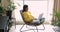 Pretty Indian woman working on laptop seated in modern armchair
