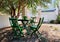 Pretty inner yard with table and chairs under lush green tree and hammock