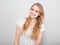 Pretty joyful toothy laughing young woman with fair blond long hair in casual dress looking with happy. Studio shot of good