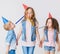Pretty kids on birthday party having fun in jeans clothes and festive cap. Studio