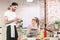 Pretty lady in eyeglasses sitting at the table with menu in hands and thoughtfully looking at waiter while making order