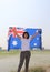pretty lady is holding Australia flag in her hands and raising to the end of the arm at the back on nature view background