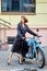 Pretty lady in long leather coat with old vintage motorbike