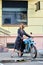 Pretty lady in long leather coat with old vintage motorbike