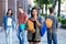 Pretty latin american young adult woman walking in city with group of students