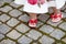 Pretty  little girl for 1 year old taking first step. Cute legs of a small child in red sandals on the street close-up