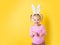 Pretty little girl easter bunny on yellow background