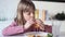 Pretty little girl eating a complete hamburger at home