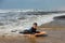 pretty little girl enjoying surfing the waves with a bodyboard during her vacation