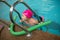 Pretty little girl learning to swim in the pool with swim coach trainer