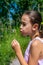 Pretty little girl picking a flower on a path surrounded by nature