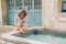 Pretty little girl playing with a fountain on a hot day