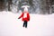 Pretty little girl in red coat in winter forest. Little girl having fun on winter day