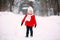 Pretty little girl in red coat in winter forest. Little girl having fun on winter day