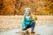 Pretty little girl squatting with leaves in hand