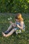 Pretty little girl in summer dress sitting in lawn in the late afternoon golden light