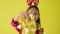 Pretty long hair girl in red sweater wearing reindeer antlers headband is dancing with golden Christmas garland happily.